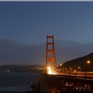 Cars crossing Golden Gate bridge at dusk