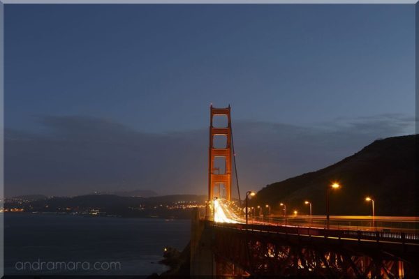 Cars crossing Golden Gate bridge at dusk